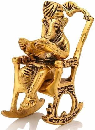 Close-up of the Golden Lord Ganesha statue reading Ramayan on a rocking chair, showcasing intricate metal craftsmanship.