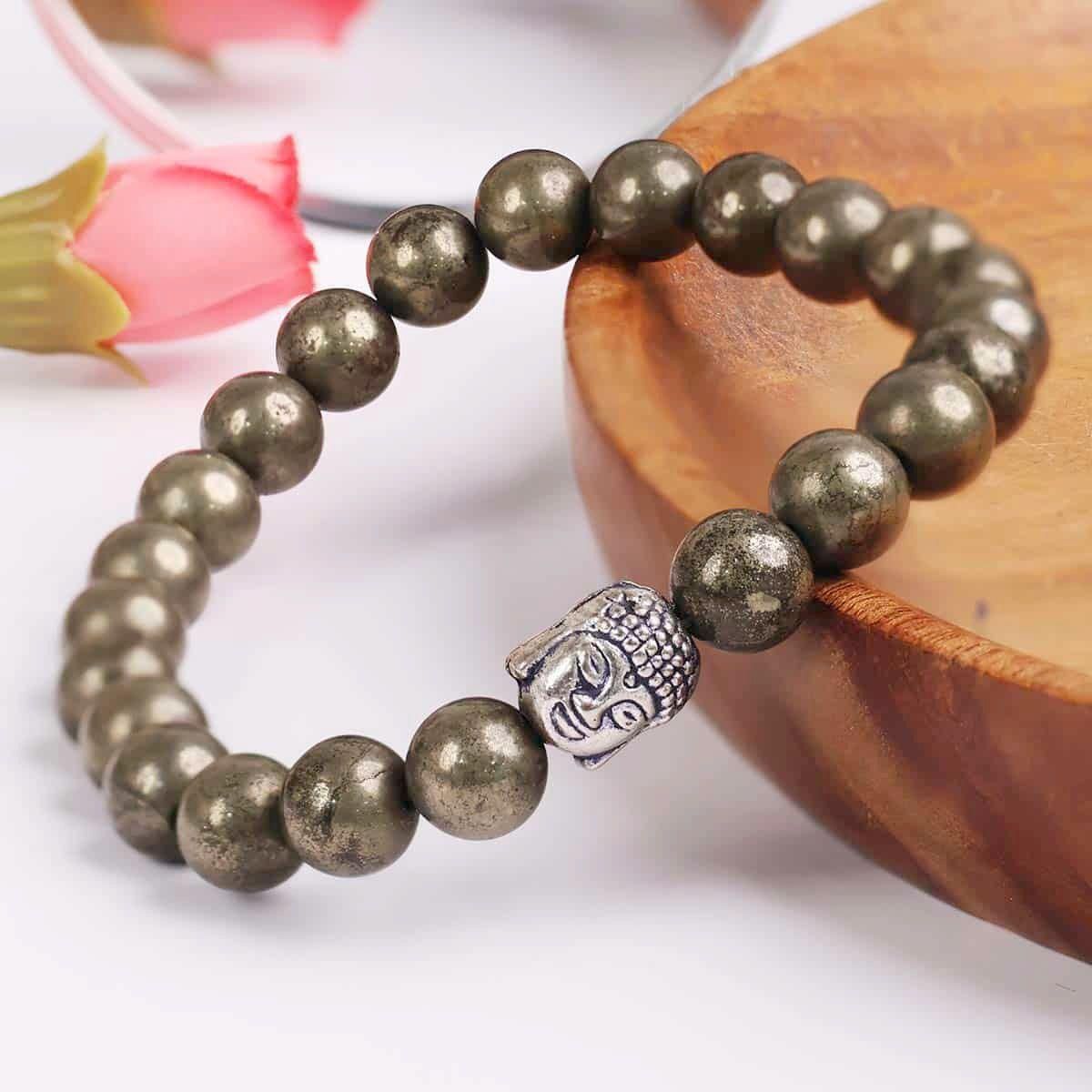 Unisex Pyrite elastic bracelet with a silver Buddha charm. This casual accessory enhances style while promoting positive energy and confidence.